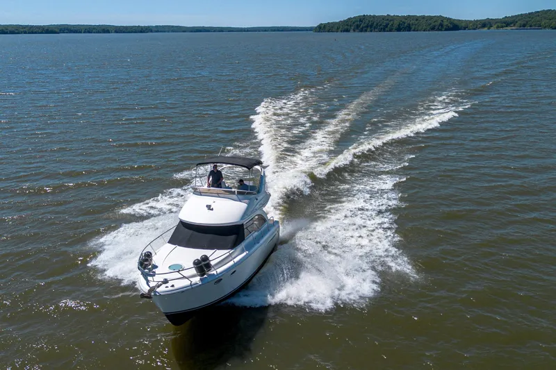 Slide: The Image of 2005 Meridian 341 Sedan cruising on a serene lake with lush green shoreline. - 19