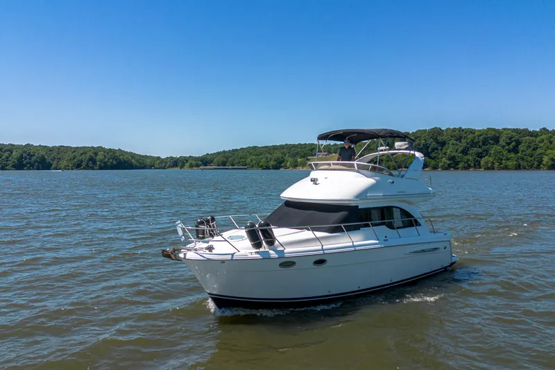 Slide: The Image of 2005 Meridian 341 Sedan yacht cruising on a serene lake under a clear blue sky. - 12