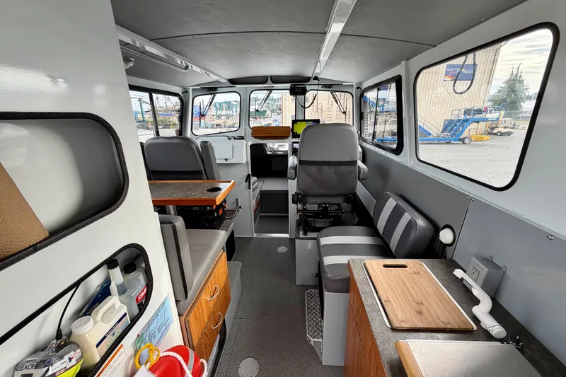 Slide: The Image of Interior of 2018 Hewescraft 260 Pacific Explorer boat, featuring seating and kitchenette. - 2