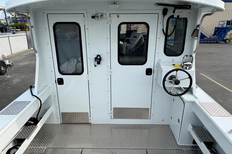 Slide: The Image of 2018 Hewescraft 260 Pacific Explorer boat cockpit with steering wheel and dual doors. - 9