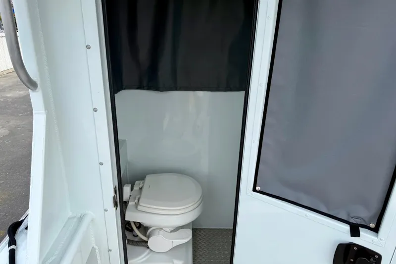 Slide: The Image of 2018 Hewescraft 260 Pacific Explorer boat interior with compact marine toilet. - 8