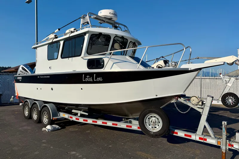 Slide: The Image of 2018 Hewescraft 250 Pacific Explorer boat on trailer, parked outdoors under clear blue sky. - 1