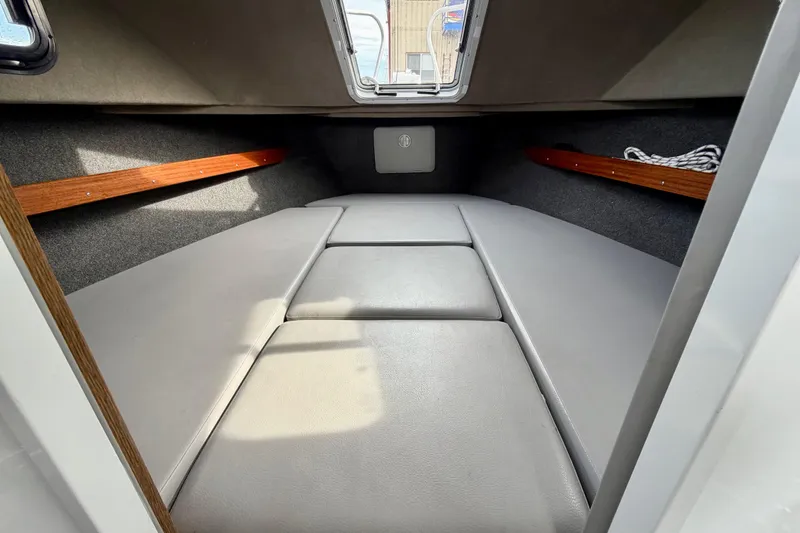 Slide: The Image of 2018 Hewescraft 260 Pacific Explorer cabin interior with cushioned seating and wooden accents. - 7