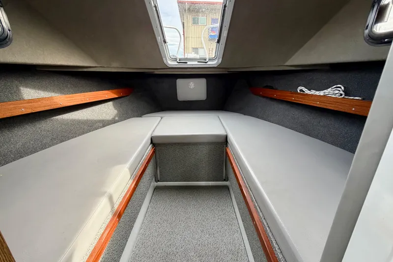 Slide: The Image of 2018 Hewescraft 260 Pacific Explorer cabin interior with gray seating and wooden accents. - 6