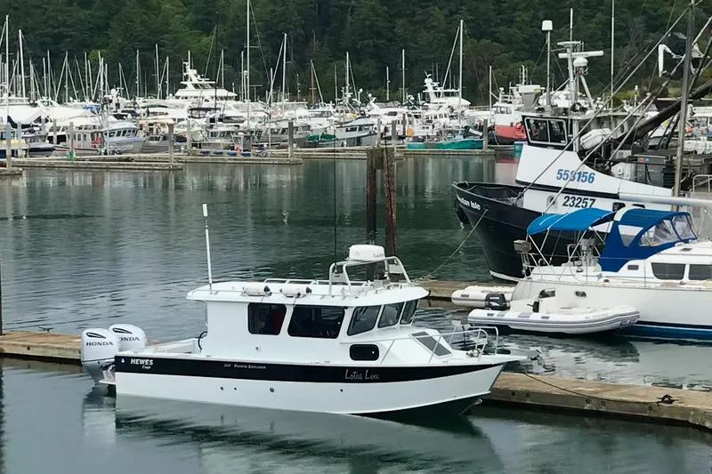 The Image of 2018 Hewescraft 250 Pacific Explorer docked in a busy marina with surrounding boats. - 3
