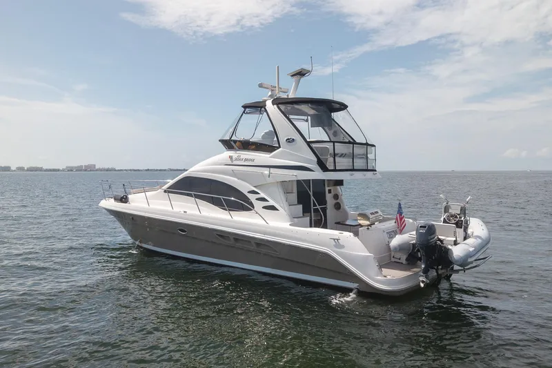 Slide: The Image of 2006 Sea Ray 455 Sedan Bridge yacht on open water under a clear sky. - 10
