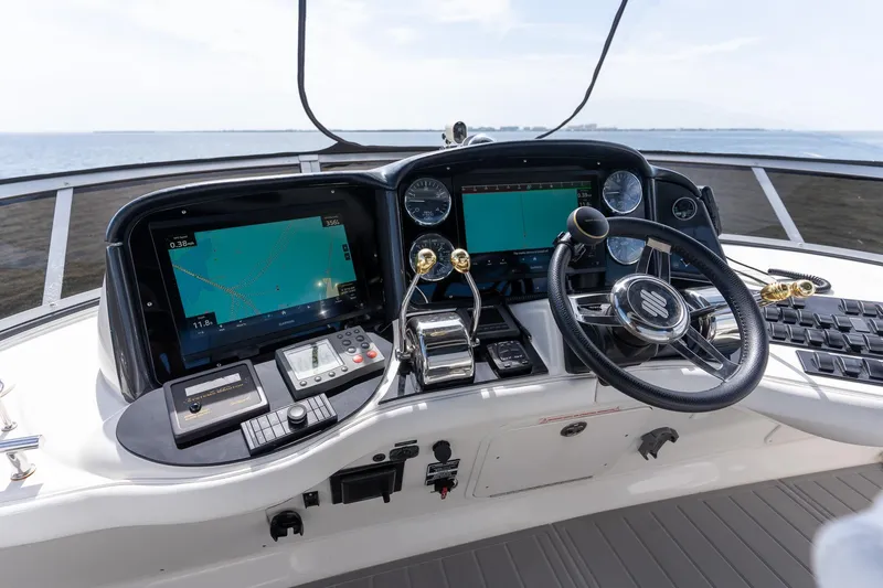 Slide: The Image of 2006 Sea Ray 455 Sedan Bridge helm with navigation screens and steering wheel. - 19