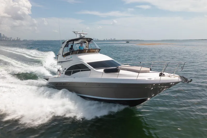 Slide: The Image of 2006 Sea Ray 455 Sedan Bridge cruising on open water, city skyline in background. - 3