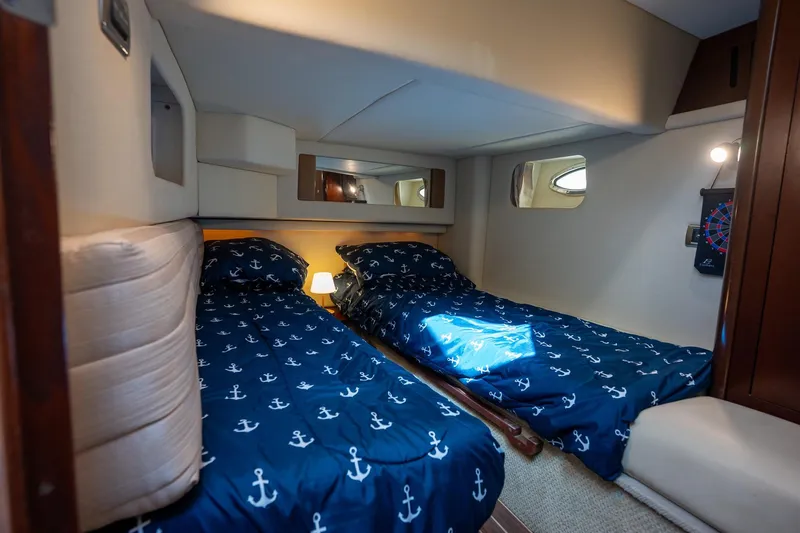 Slide: The Image of Interior cabin of 2006 Sea Ray 455 Sedan Bridge with twin beds and nautical decor. - 15