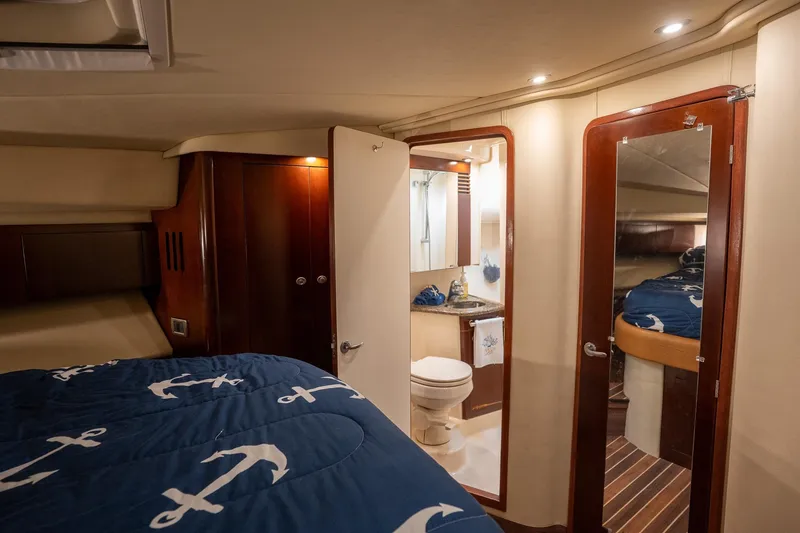 Slide: The Image of Luxurious 2006 Sea Ray 455 Sedan Bridge cabin with nautical-themed bedding and ensuite bathroom. - 25
