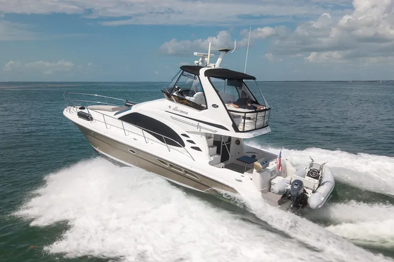 Slide: The Image of 2006 Sea Ray 455 Sedan Bridge cruising on open water under a clear sky. - 11
