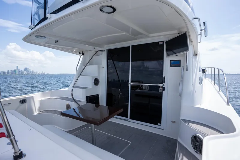 Slide: The Image of 2006 Sea Ray 455 Sedan Bridge yacht with city skyline in the background. - 13