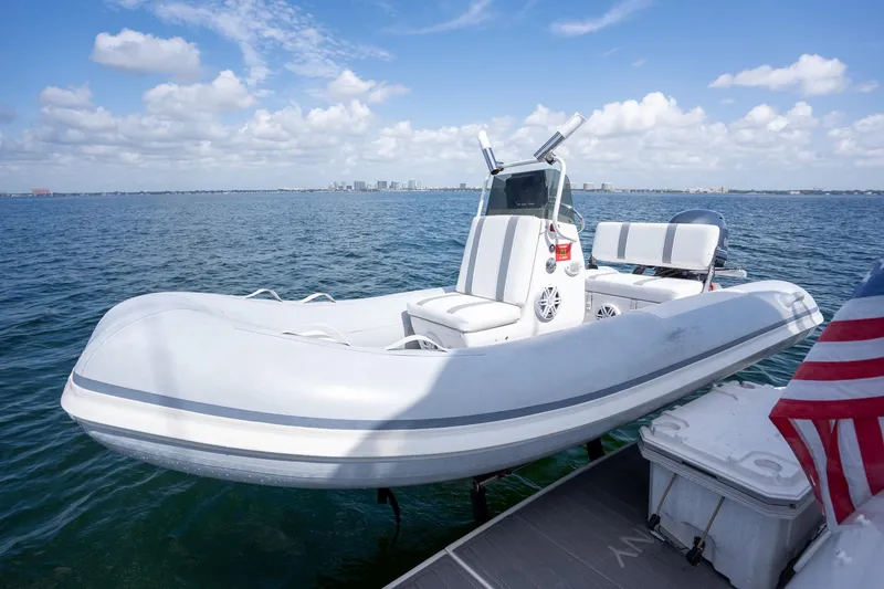 Slide: The Image of White inflatable boat docked on calm water under a blue sky. - 5