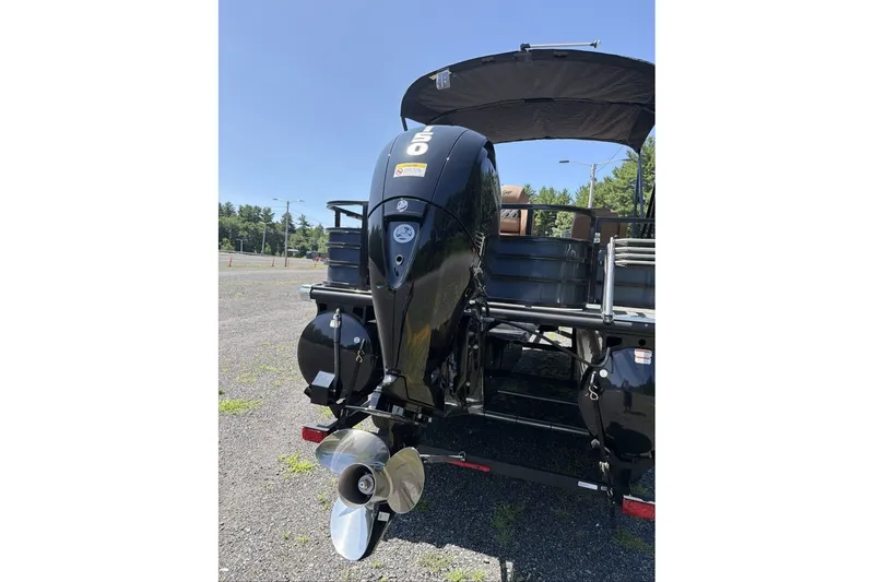 Slide: The Image of 2026 Ranger 220FC boat with powerful outboard motor, parked outdoors on a sunny day. - 11