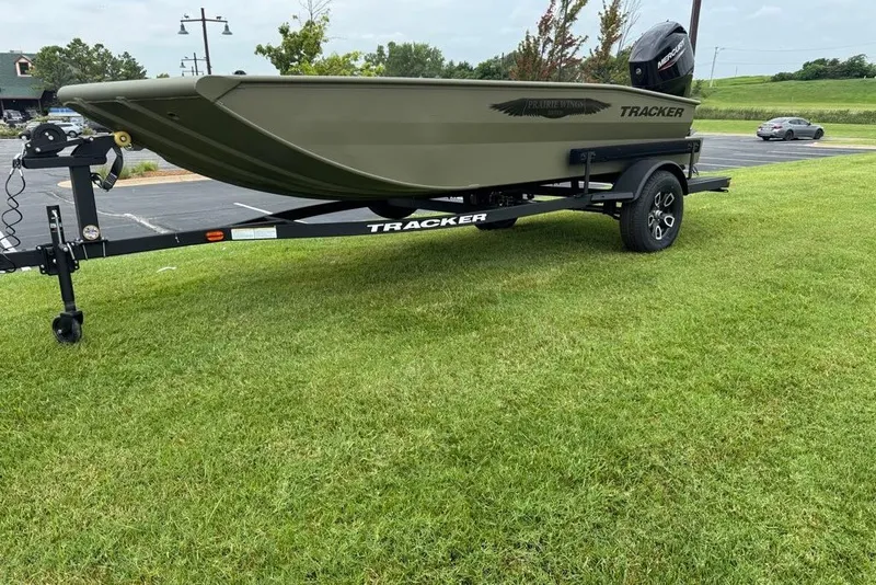 Slide: The Image of 2026 Tracker Grizzly 1650 T Prairie Wings Edition boat on trailer, parked on grass. - 6