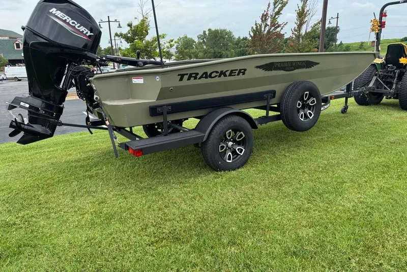 Slide: The Image of 2026 Tracker Grizzly 1650 T Prairie Wings Edition boat on trailer, parked on grass. - 4