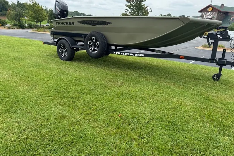 Slide: The Image of 2026 Tracker Grizzly 1650 T Prairie Wings Edition boat on trailer, parked on grass. - 5