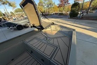 Slide: The Image of 2026 Tracker Grizzly 1650 T Prairie Wings Edition boat with open storage compartment. - 2