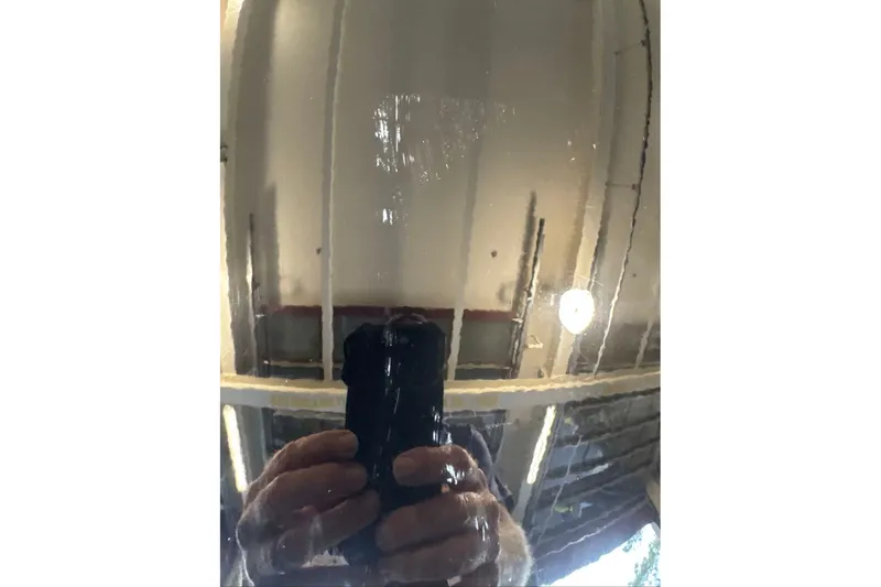 Slide: The Image of Reflection on a glossy surface, capturing a person holding a camera, indoors. - 10