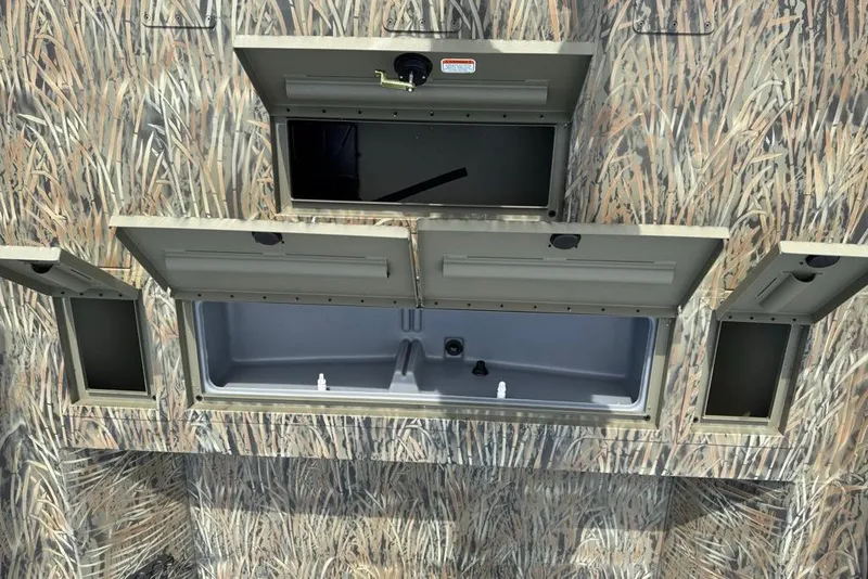 Slide: The Image of 2026 Tracker Grizzly 2072 CC boat storage compartments with camouflage design. - 9