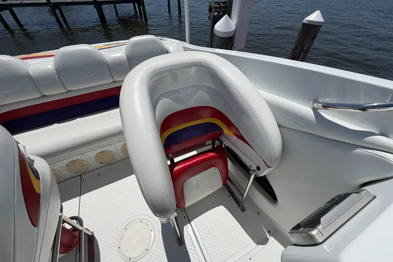 Slide: The Image of 2002 Baja 25 Outlaw boat interior with colorful seating and waterfront view. - 15