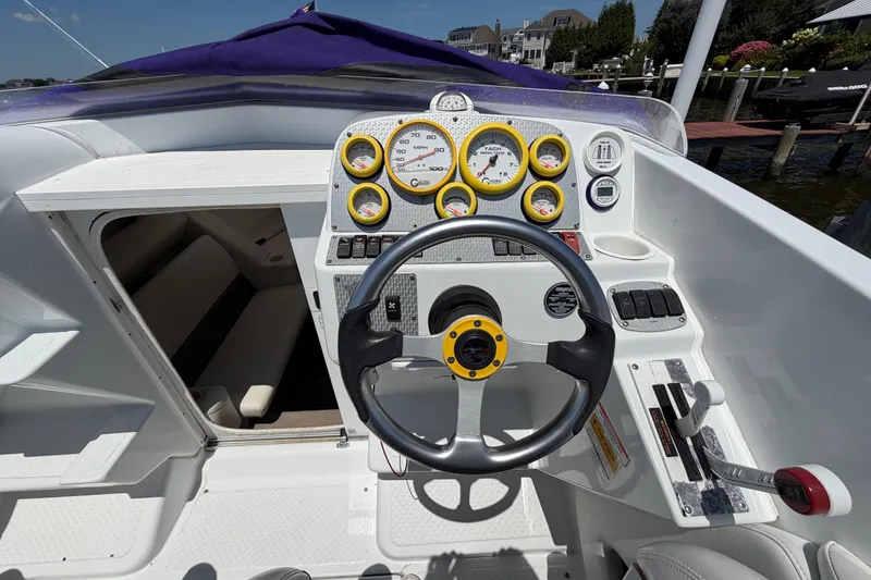 Slide: The Image of 2002 Baja 25 Outlaw boat cockpit with steering wheel and instrument panel. - 19