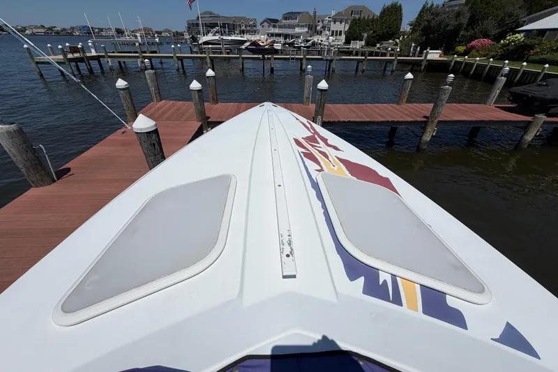 Slide: The Image of 2002 Baja 25 Outlaw boat docked at a marina with scenic waterfront views. - 21