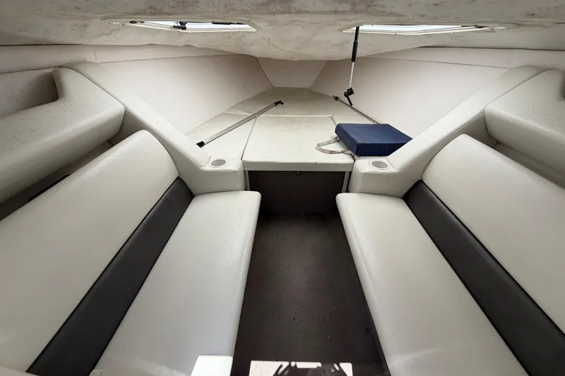 Slide: The Image of 2002 Baja 25 Outlaw boat interior with white seating and small table. - 22
