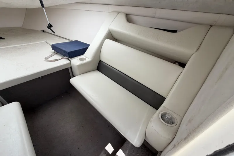 Slide: The Image of Interior of a 2002 Baja 25 Outlaw boat with white seating and cup holders. - 24