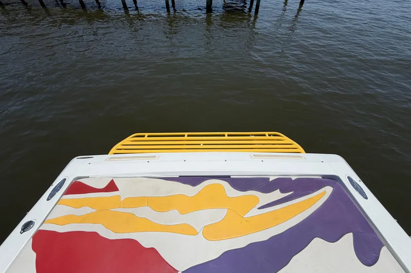 Slide: The Image of 2002 Baja 25 Outlaw boat with colorful deck design on water. - 11