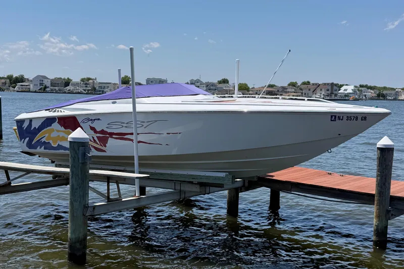 Slide: The Image of 2002 Baja 25 Outlaw speedboat docked on a sunny day, featuring vibrant graphics. - 9