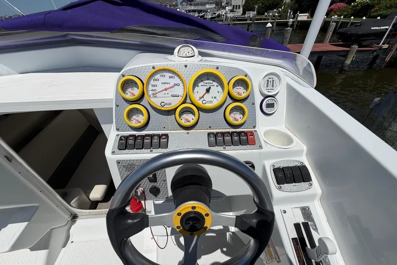 Slide: The Image of 2002 Baja 25 Outlaw boat dashboard with gauges and steering wheel. - 17