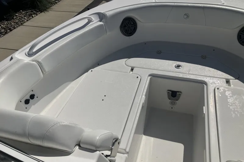 Slide: The Image of 2018 Edgewater 248CX Crossover boat interior with white seating and storage compartments. - 12
