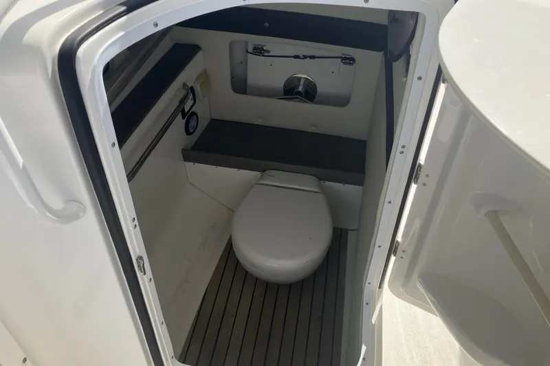 Slide: The Image of 2018 Edgewater 248CX Crossover boat interior with compact marine toilet. - 8