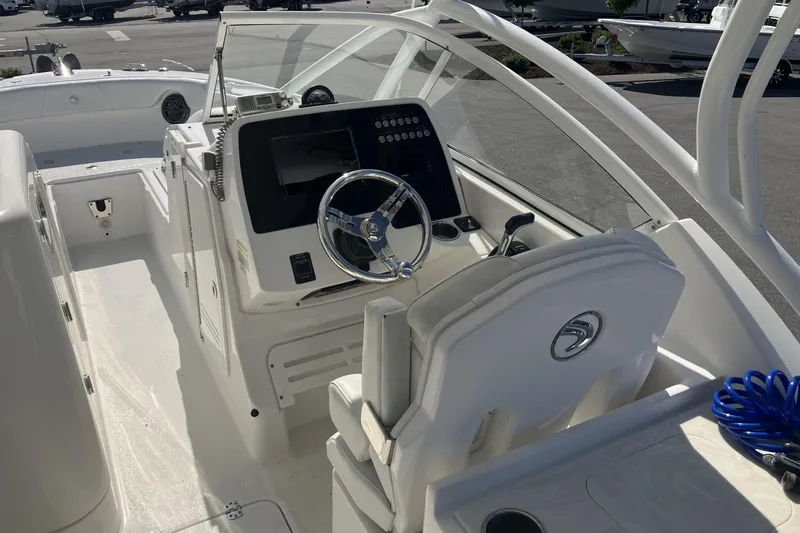 Slide: The Image of 2018 Edgewater 248CX Crossover boat cockpit with steering wheel and control panel. - 10