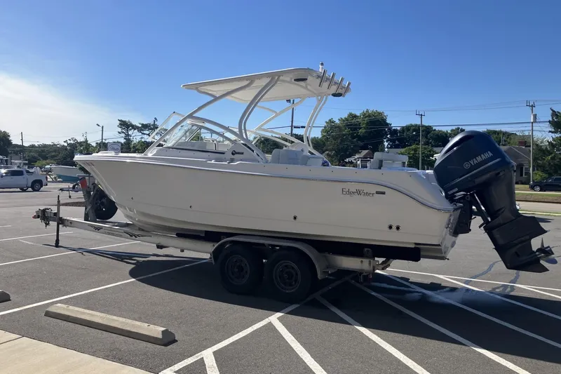 Slide: The Image of 2018 Edgewater 248CX Crossover boat on trailer in parking lot, sunny day. - 5