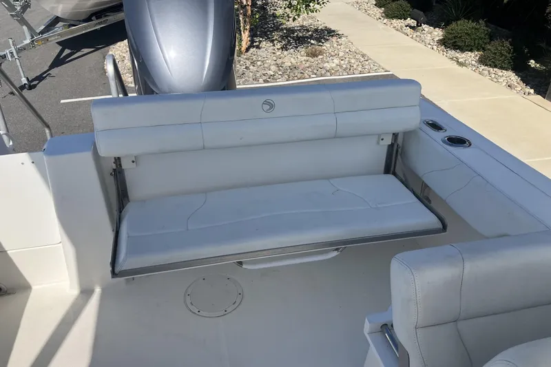 Slide: The Image of 2018 Edgewater 248CX Crossover boat interior with white seating and cup holders. - 18