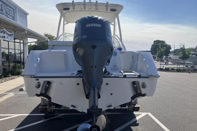 Slide: The Image of 2018 Edgewater 248CX Crossover boat with powerful outboard motor in a parking lot. - 7
