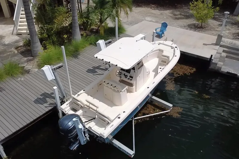 Slide: The Image of 2021 Grady-White 251 Coastal Explorer boat docked on a lift by a waterfront. - 13