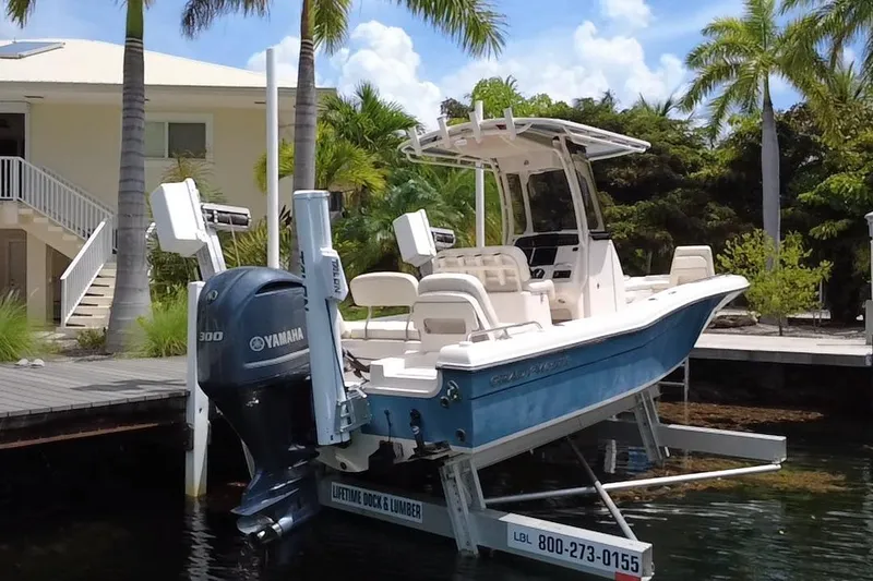 Slide: The Image of 2021 Grady-White 251 Coastal Explorer boat docked with Yamaha engine, surrounded by palm trees. - 11