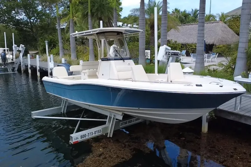 Slide: The Image of 2021 Grady-White 251 Coastal Explorer boat docked near palm trees. - 2