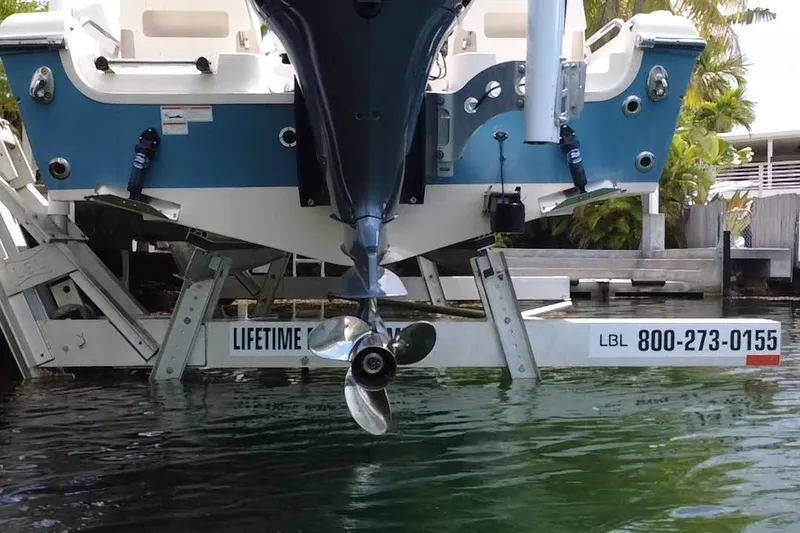 Slide: The Image of 2021 Grady-White 251 Coastal Explorer on lift, showcasing propeller and hull design. - 5