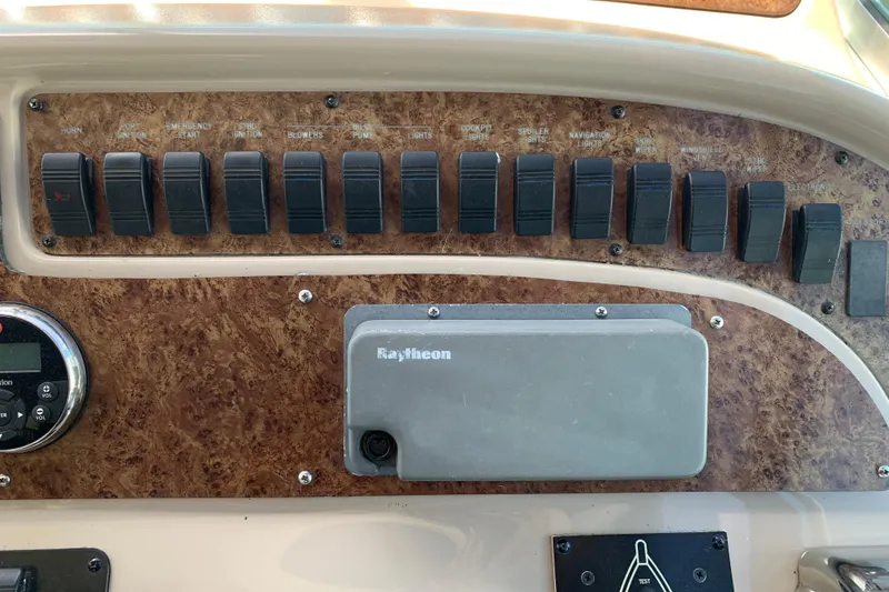 Slide: The Image of Control panel of a 2000 Sea Ray Sundancer 310 boat with switches and Raytheon equipment. - 19