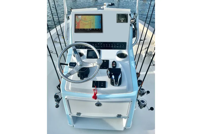 Slide: The Image of Manufacturer Provided Image: 2026 Pathfinder 2500 Hybrid boat console with steering wheel, navigation screen, and fishing rod holders. - 32
