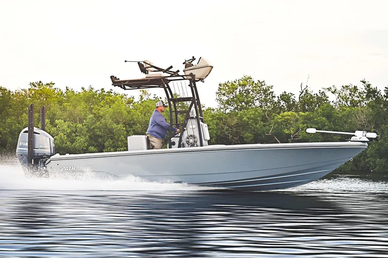Slide: The Image of Manufacturer Provided Image: 2026 Pathfinder 2500 Hybrid boat cruising on water near lush greenery. - 25