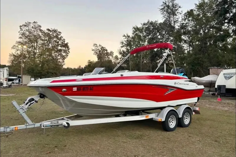 Slide: The Image of 2021 Crownline Eclipse E205 XS boat on trailer, red and white design, parked outdoors. - 1