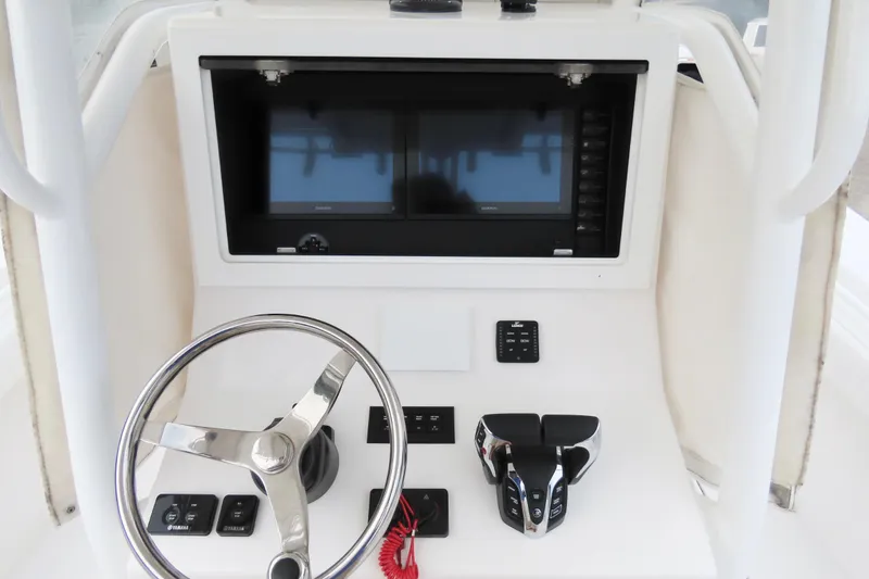 Slide: The Image of Dashboard of a 2008 Onslow Bay 27 Offshore Edition boat with steering wheel and controls. - 12