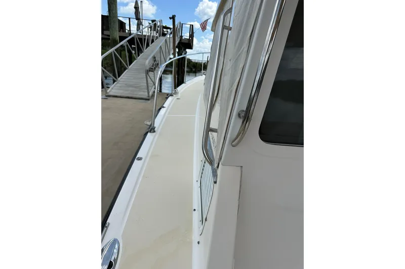 Slide: The Image of Side view of 2007 True North 38 Heritage boat docked by a ramp. - 27
