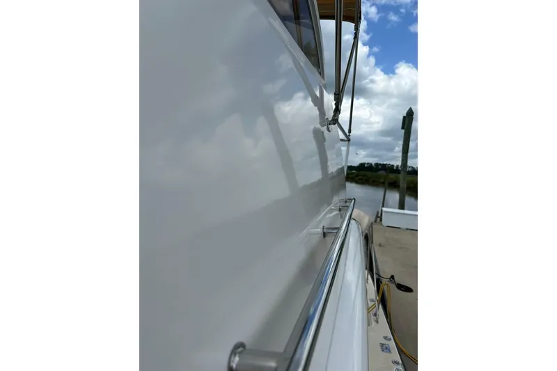 Slide: The Image of Side view of 2007 True North 38 Heritage boat docked by a calm river. - 34