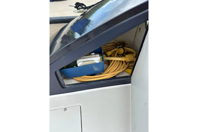 Slide: The Image of Storage compartment on 2007 True North 38 Heritage boat with hoses and cleaning supplies. - 21